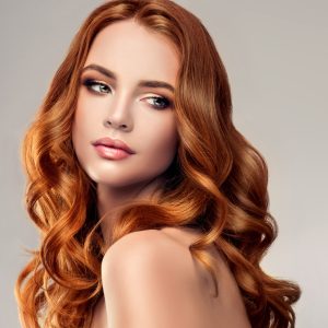 Beautiful model girl with long red curly hair .Red head . Care and beauty hair products