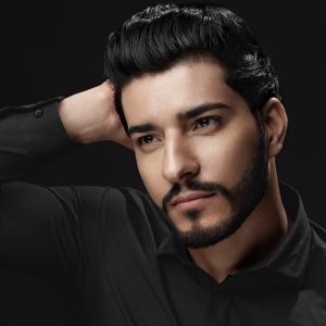 Men Hair Beauty. Handsome Male Model Touching Healthy Hair